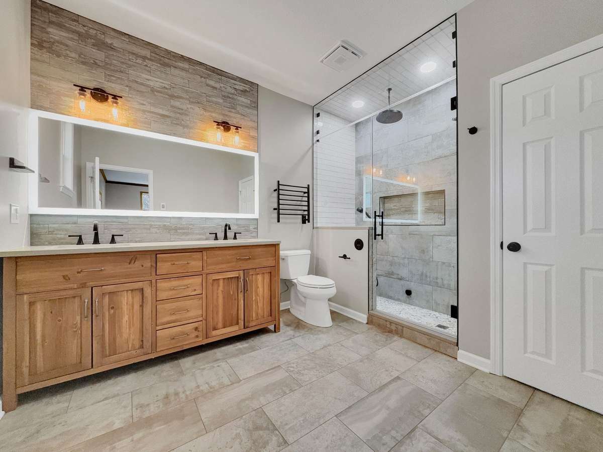 Updated primary bath featuring a double vanity and a spa-like rain shower with sauna.