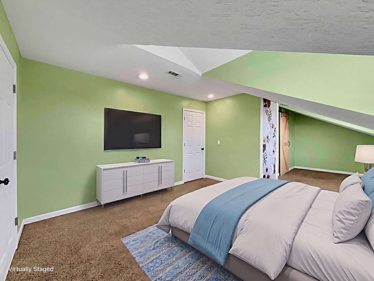 Second-level bedroom featuring a full bath and a stylish barn door.