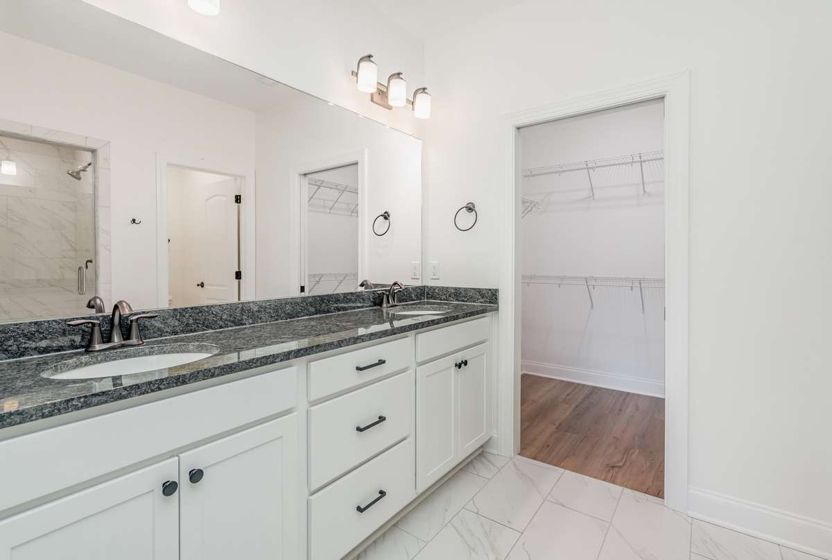 Primary bathroom with double vanities and large walk-in closet