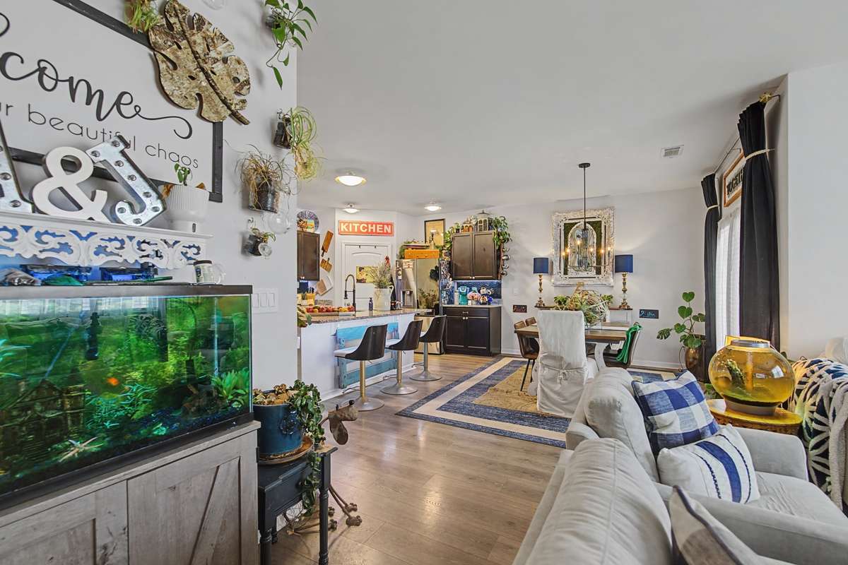 Living Room: Bright, open-concept living area with durable engineered hardwood flooring and seamless flow into the kitchen.