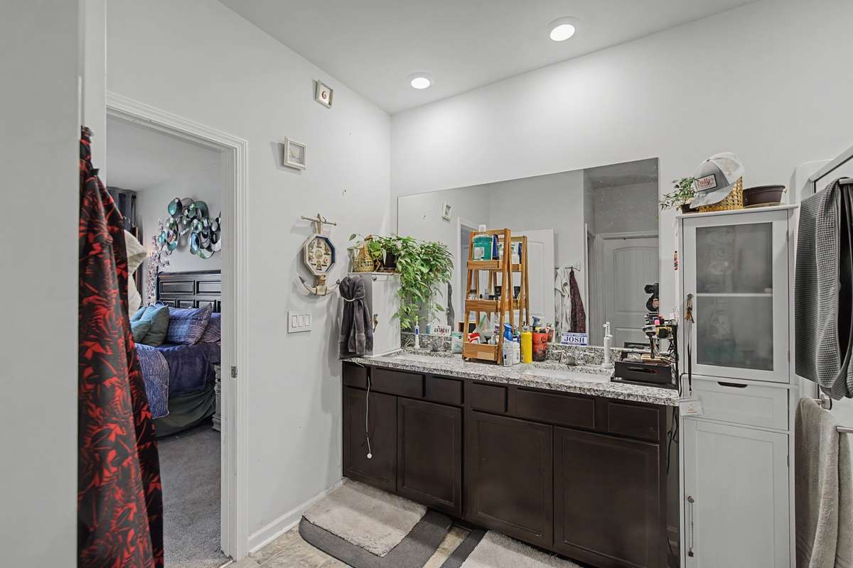 Primary Bathroom: Private primary ensuite with an expansive double vanity, granite counters, and updated lighting
