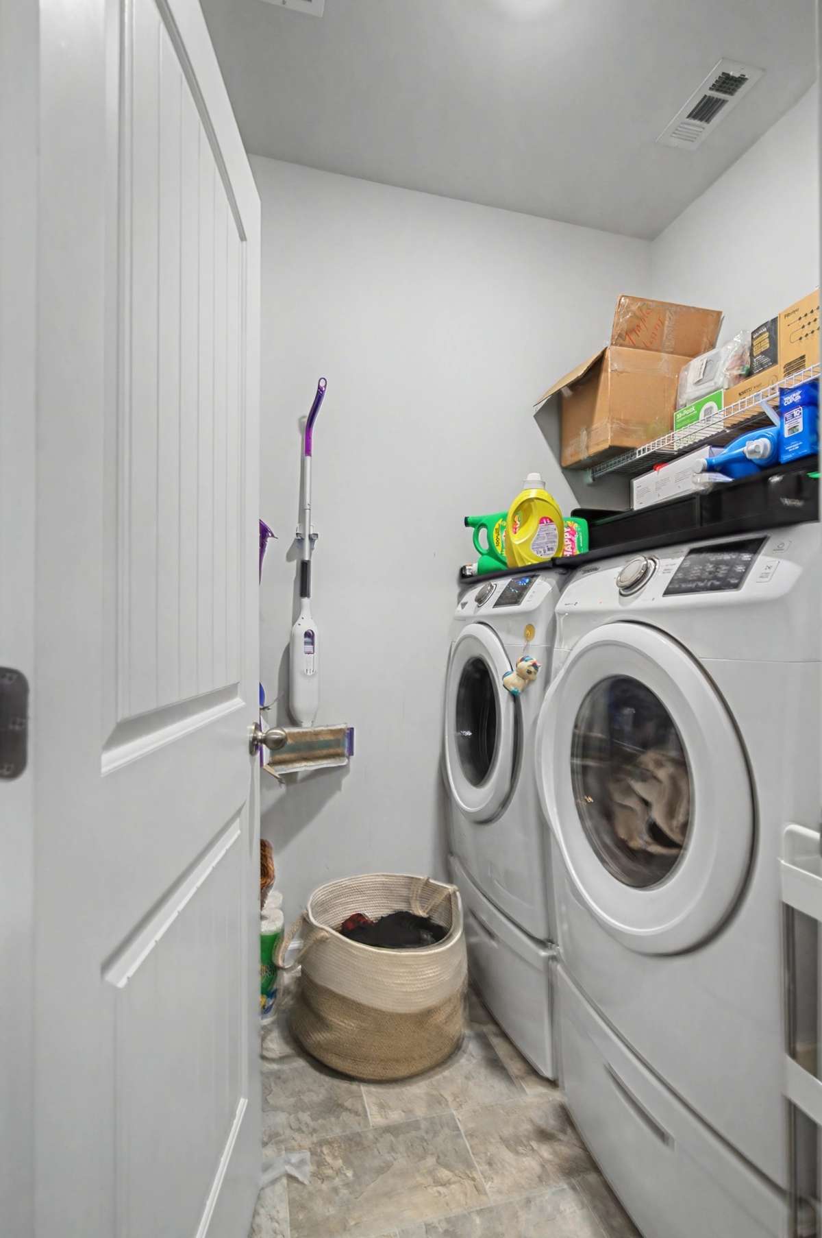 Laundry Room: Convenient dedicated laundry room with built-in shelving and ample space for side-by-side units
