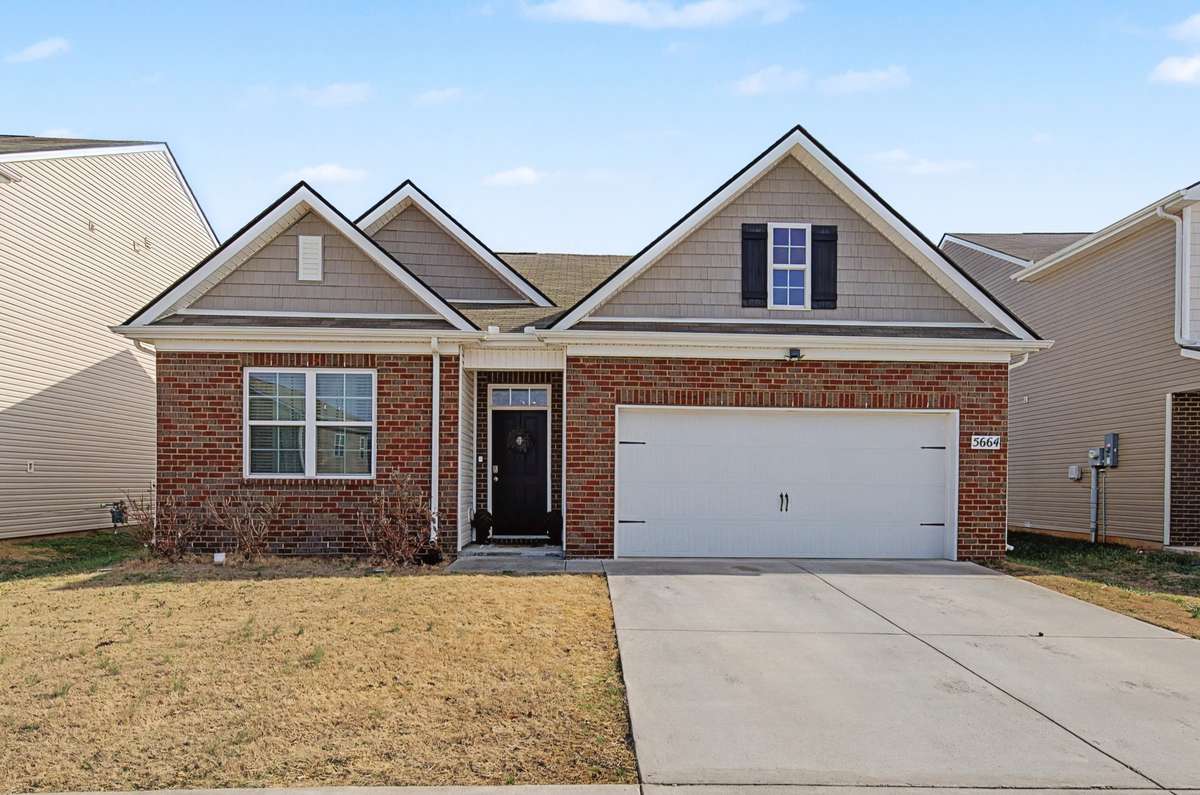 Front Exterior: Charming brick and vinyl facade featuring a classic gabled roofline and an attached two-car garage.