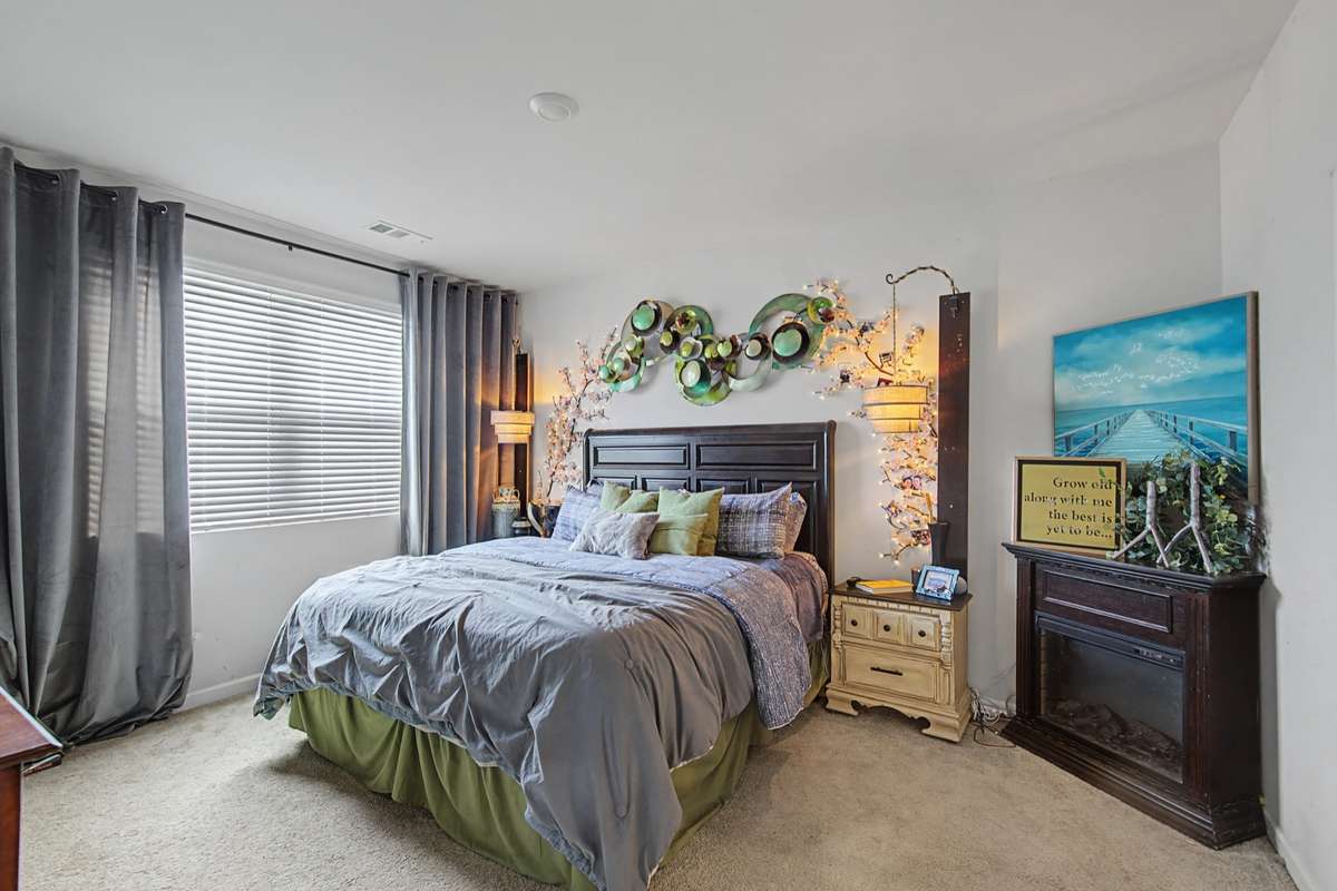 Primary Bedroom: Generous primary suite featuring plush neutral carpeting and a large window overlooking the grounds