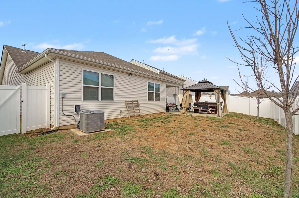 Backyard (Wide View): Large, level backyard fully enclosed with a white privacy fence for ultimate seclusion