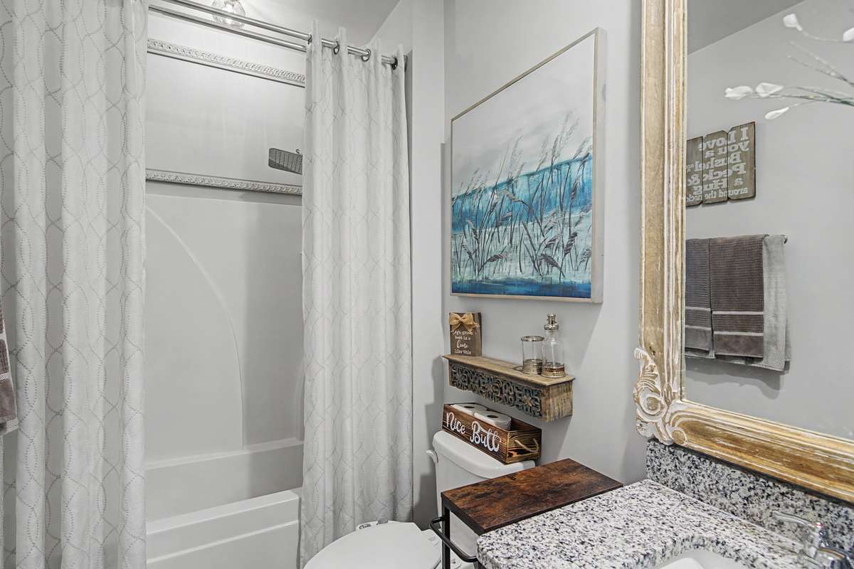 Guest Bathroom: Full guest bathroom featuring a granite-topped vanity and a clean tub/shower combination