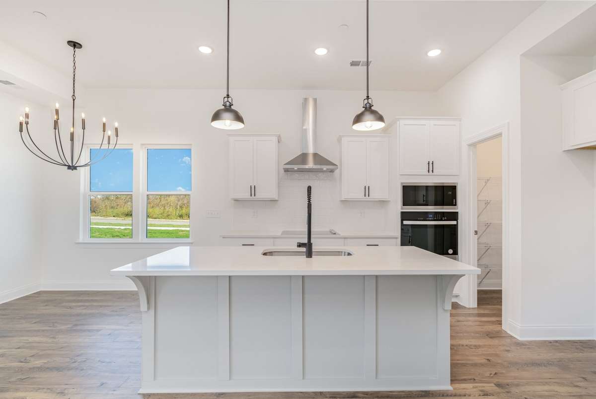 Photo to show available kitchen upgrade w/ hood vent,  built-in microwave and oven. You can truly make this home just the way you like it! *Photos not of exact home*