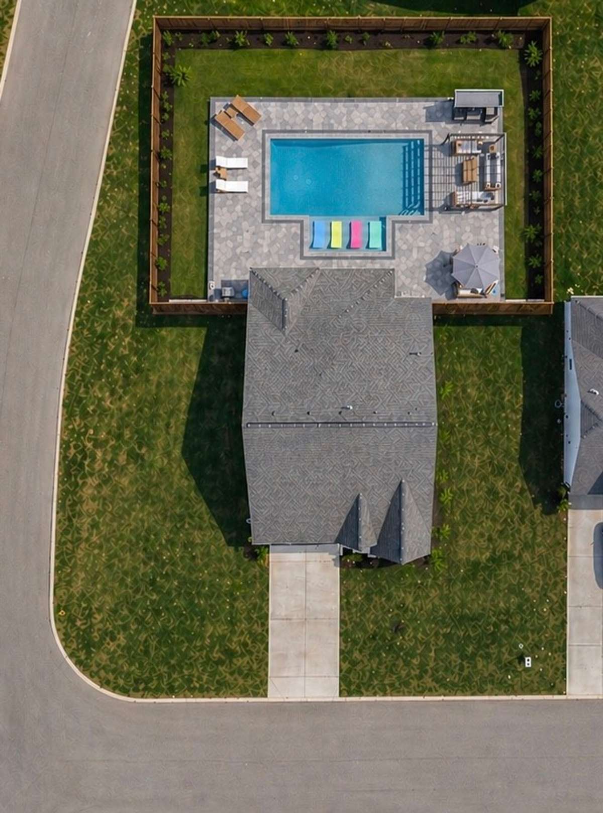 Virtually staged fenced backyard with pool and outdoor living.