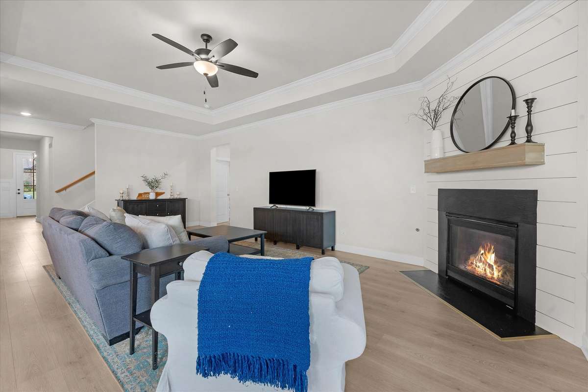 The vented gas fireplace surrounded by a shiplap accent wall with mantle is a beautiful touch