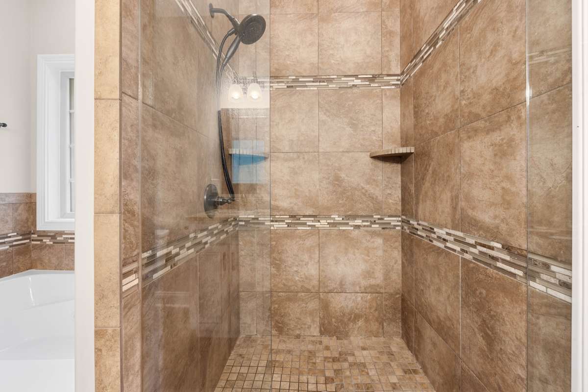 tile shower separate from the tub in the bedroom on the main level