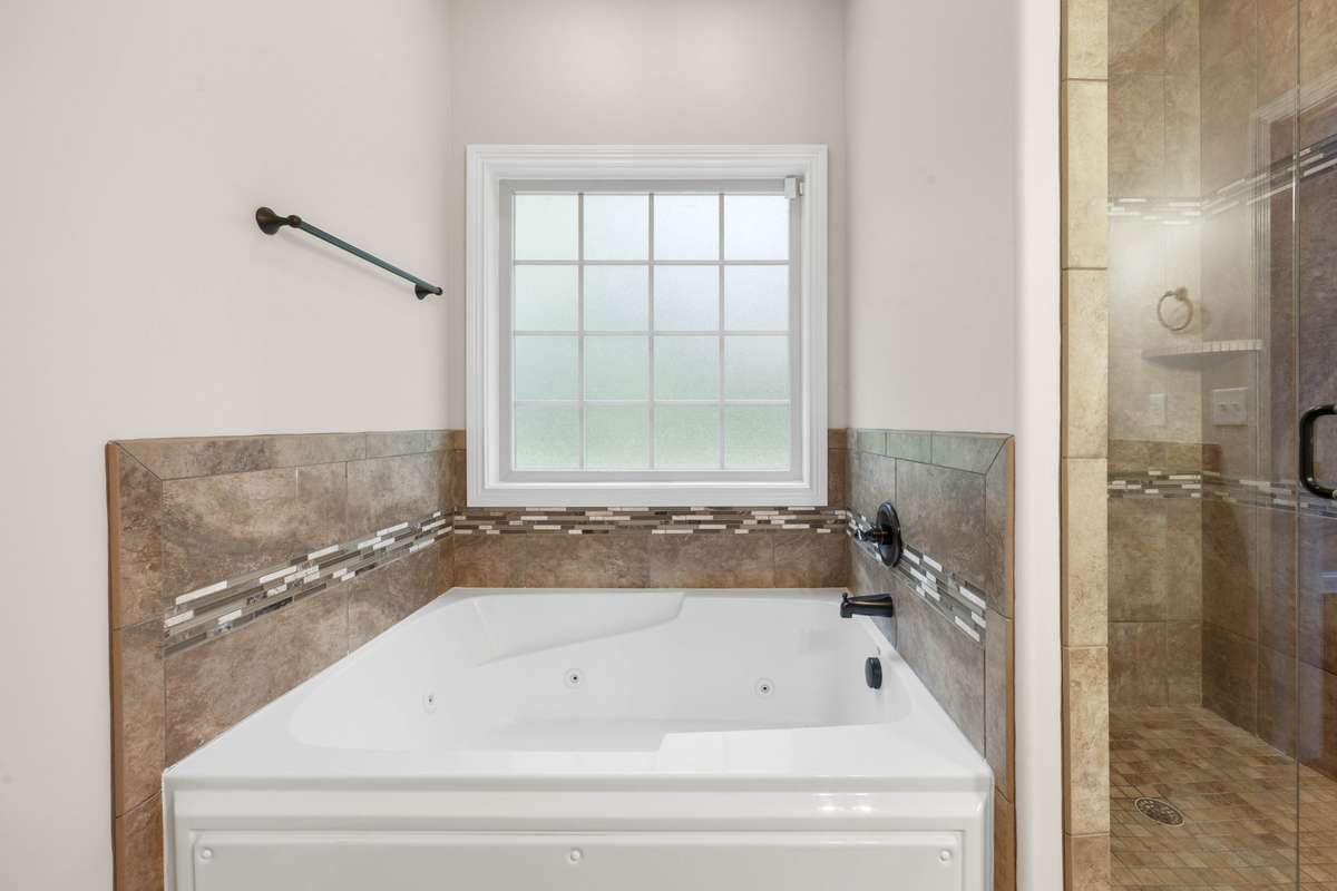 spa tub in the bedroom on the main level, separate from the tile shower