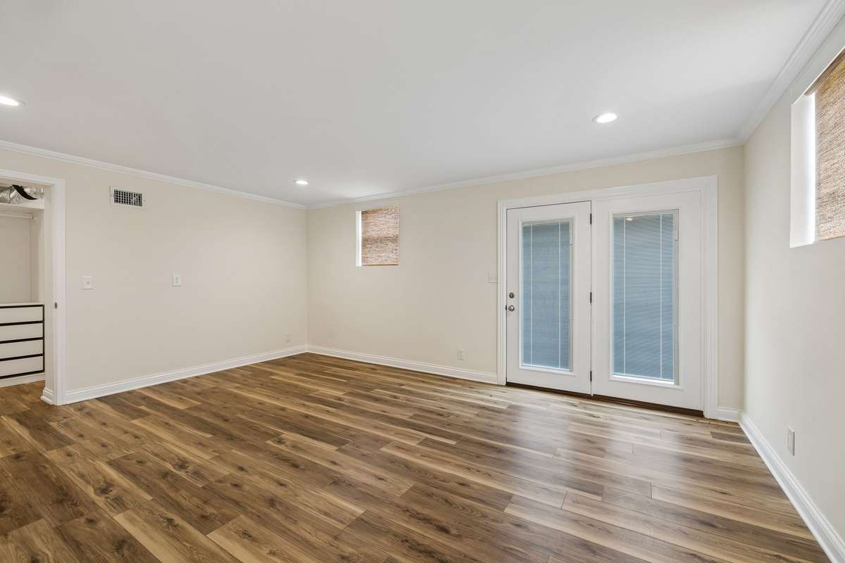 Basement bedroom with doors to brick patio