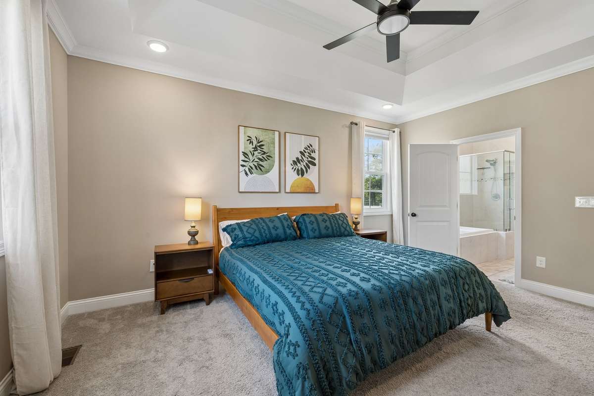 Primary Bedroom on the main level features tray ceiling with recessed lighting