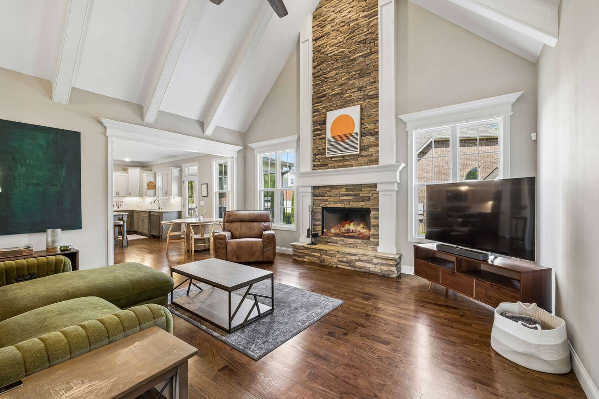 Stunning Great Room features a soaring ceiling, recessed lighting, gas fireplace and real sand and finish hardwood floors