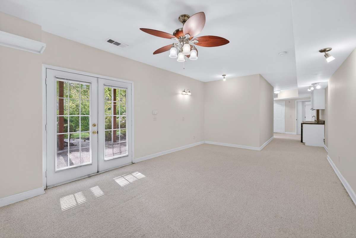 Living area in basement with doors leading to covered patio.