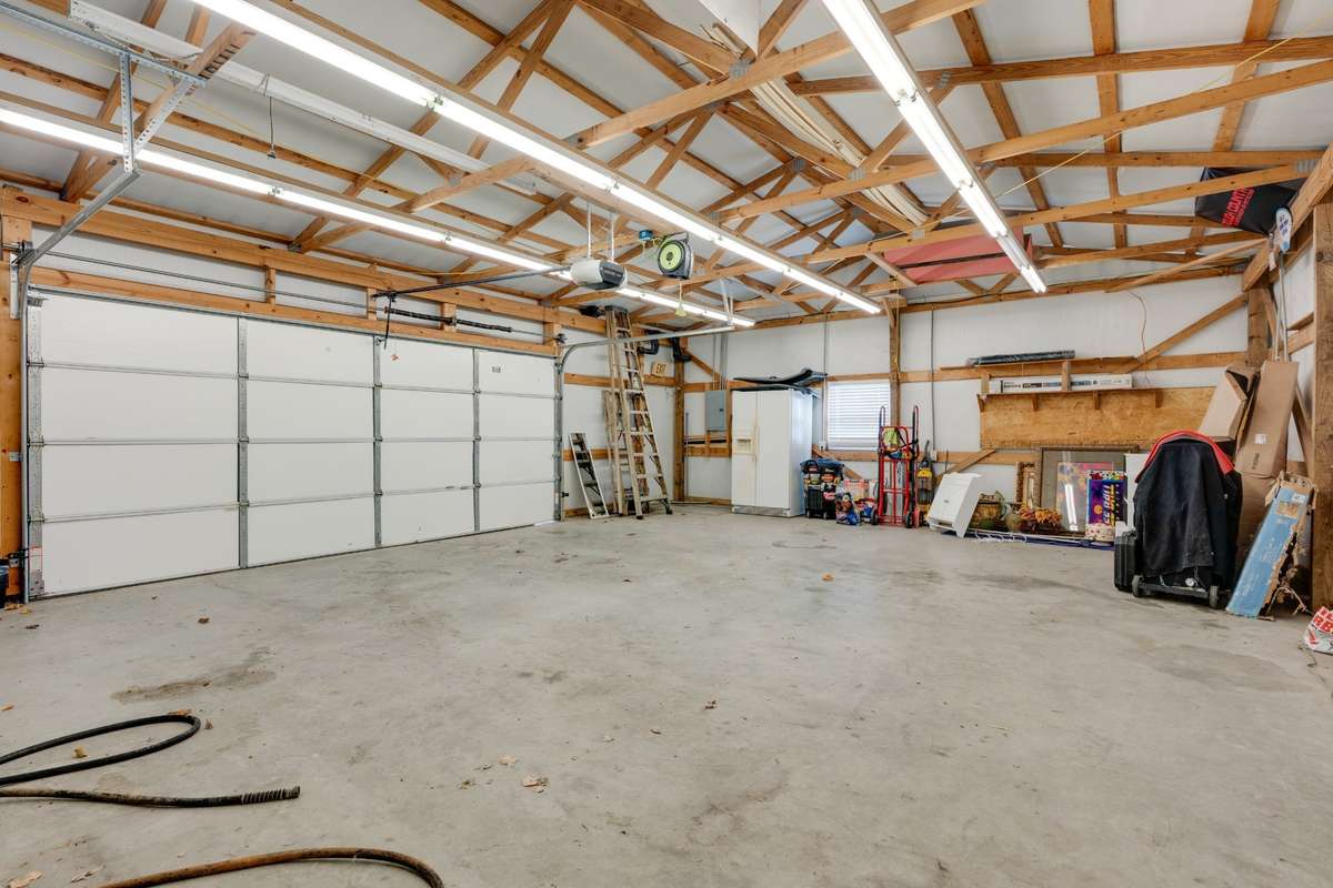 Super well-lit detached garage with garage door opener and insulated door.