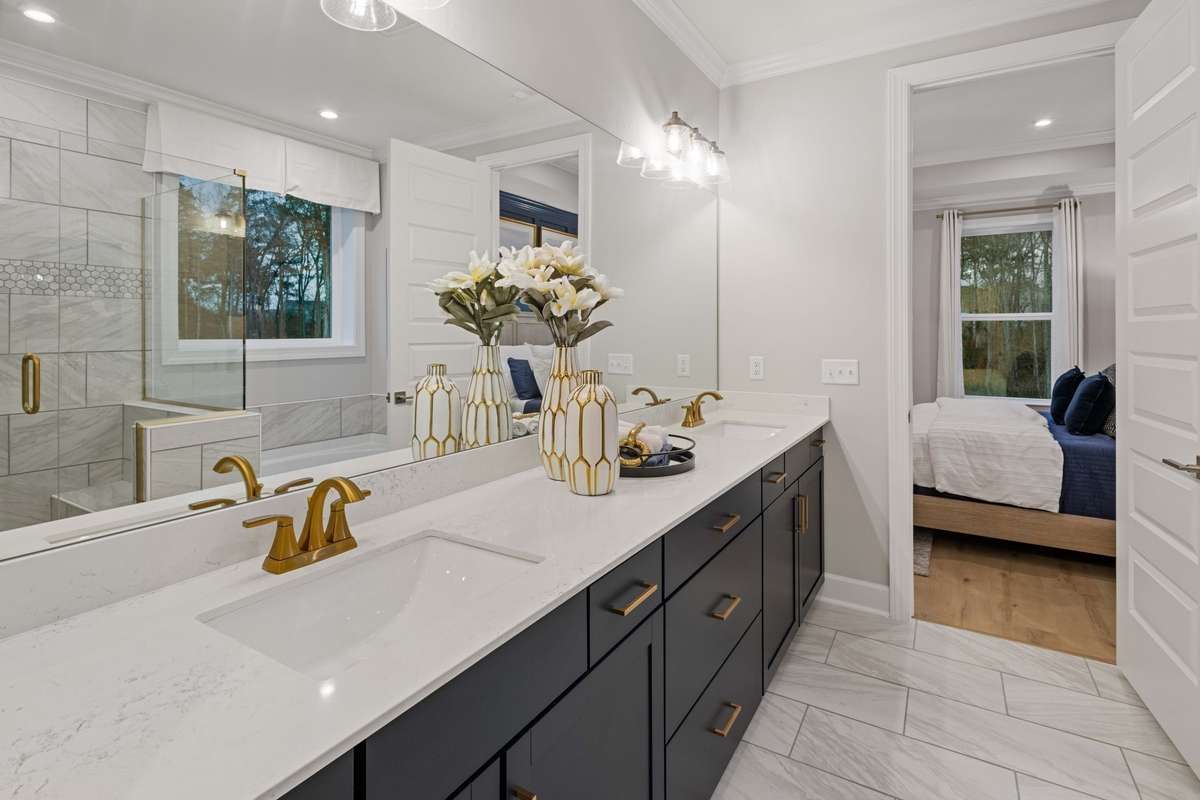 Live in luxury in your primary suite oasis featuring tiled walk-in shower, separate tub, ceramic tile floors, double vanities, and quartz countertops!