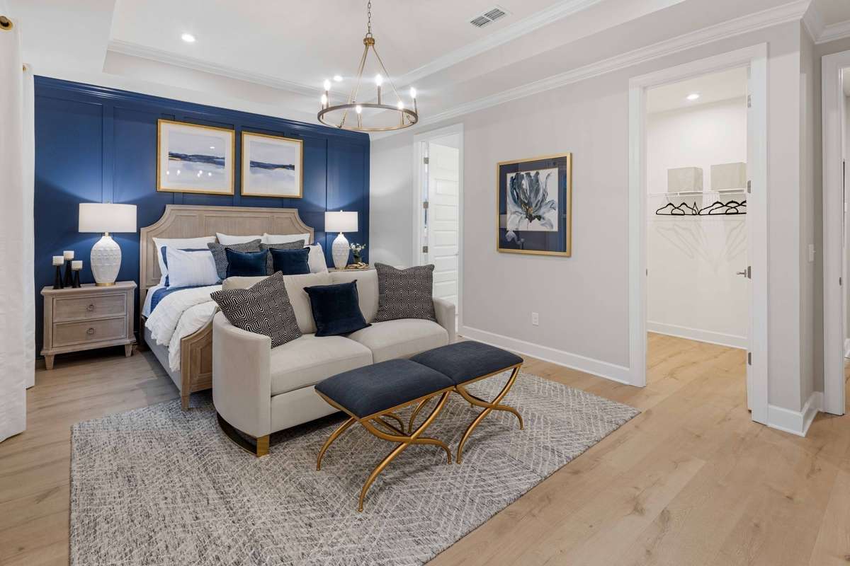 Huge primary suite on the first floor features TWO walk-in closets! King size furnishings shown here. Trey ceiling included.