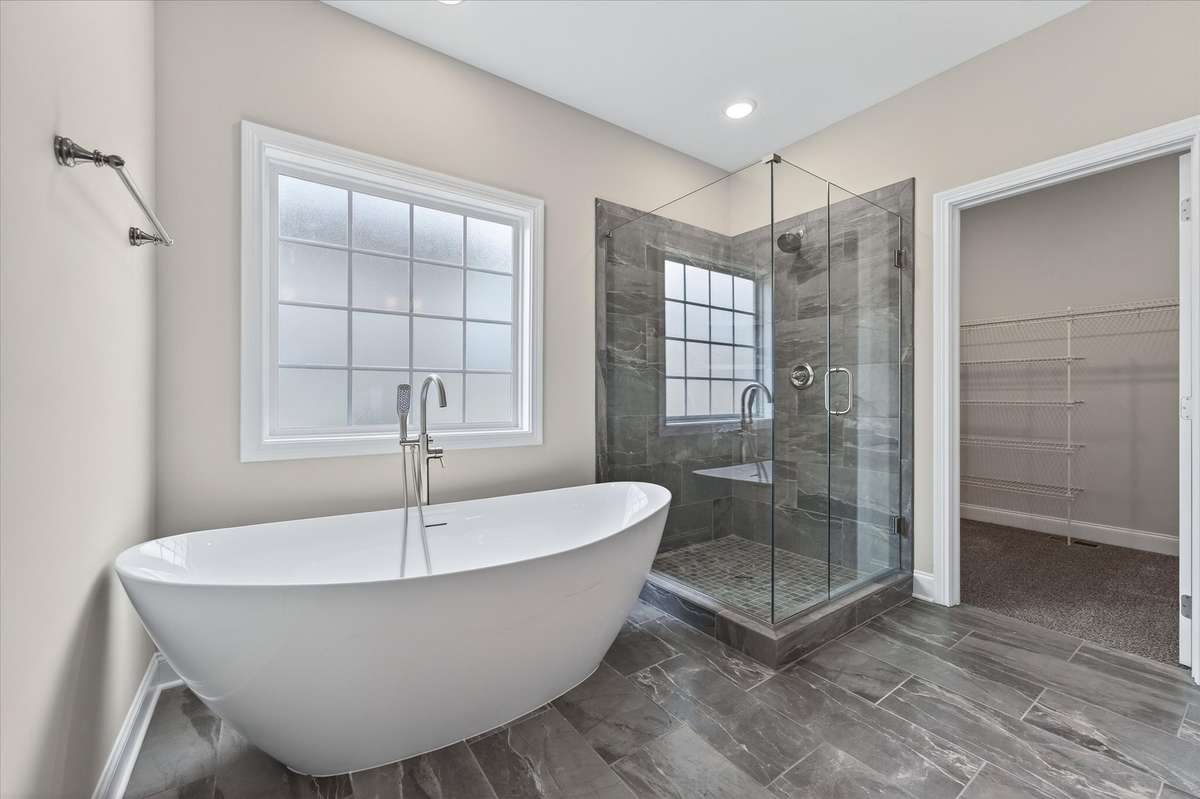 Spa-like primary bath with modern tile finishes and glass shower.