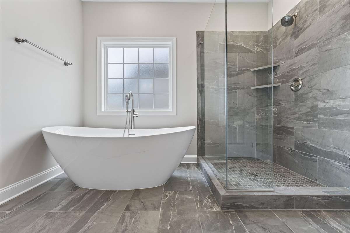 Luxury en suite bath with freestanding soaking tub and tiled walk-in shower