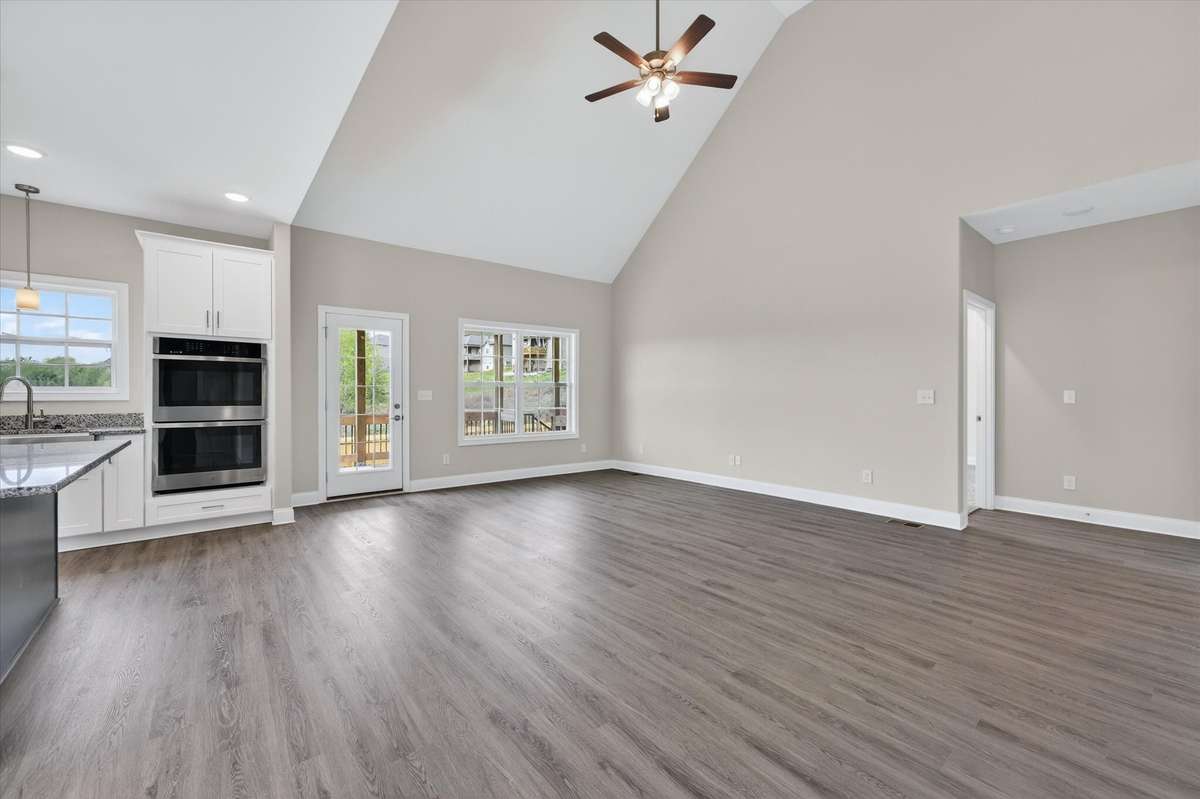 Open-concept living room with vaulted ceilings and abundant natural light