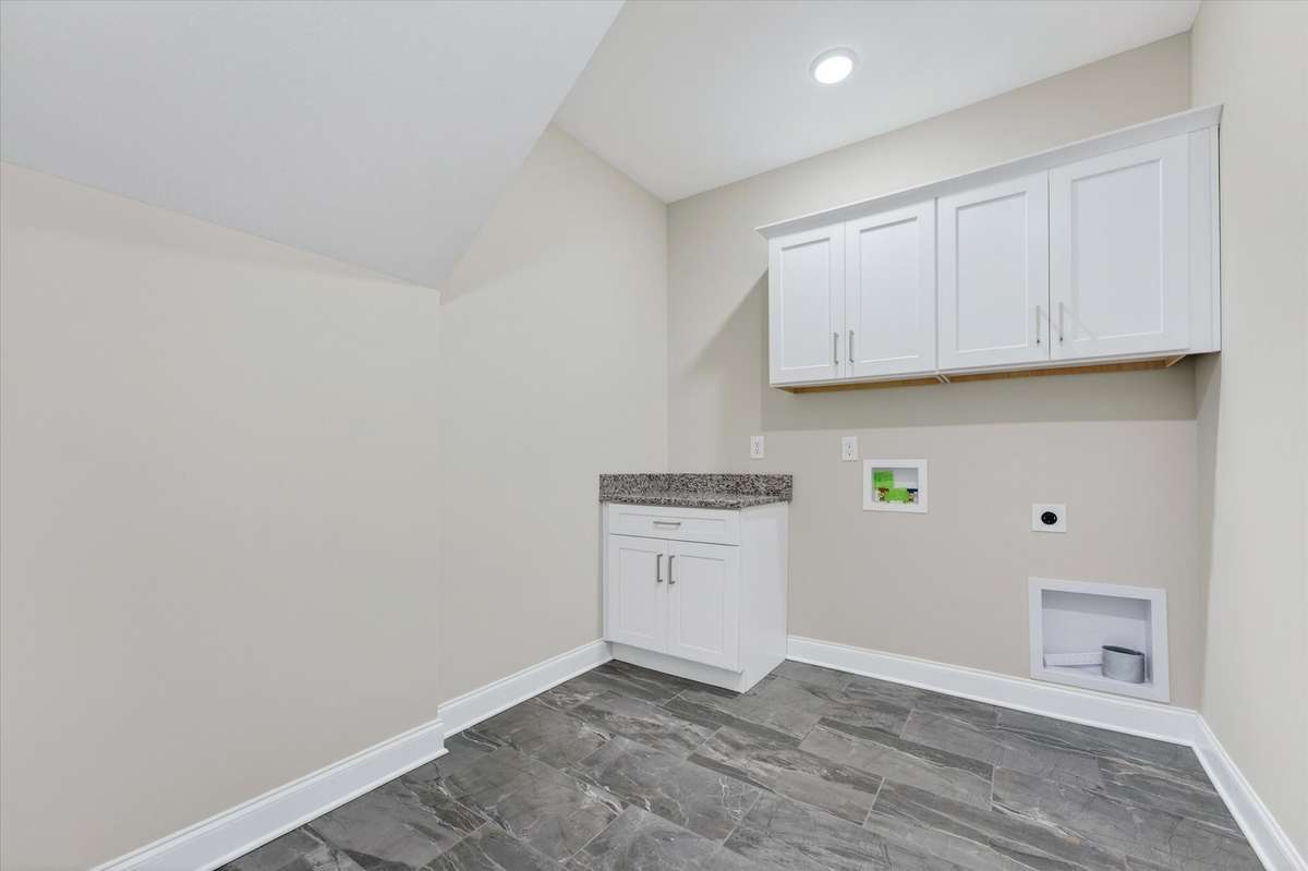 Dedicated laundry room with cabinetry and workspace.