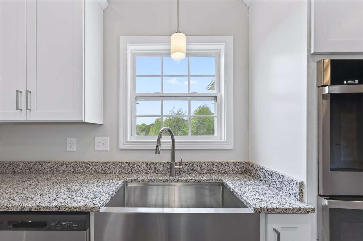 Kitchen with granite countertops, stainless sink, and modern finishes