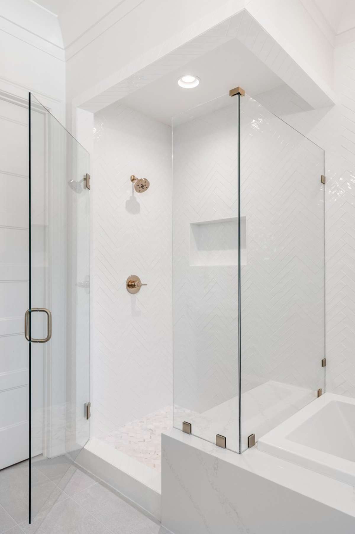 Primary Bath Tiled shower with frameless shower door.