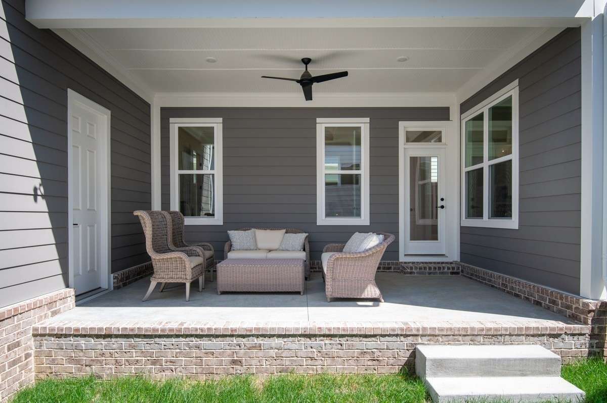 Covered side porch with steps leading to sod and irrigated fenced in courtyard.