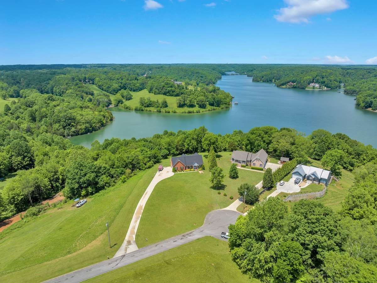 Aerial view of the home (black roof) with the lake in the background.