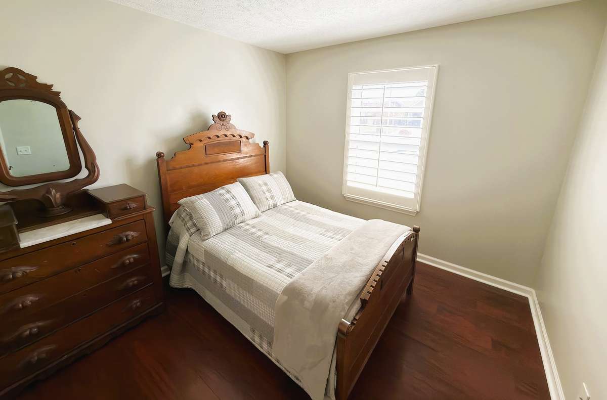 Another angle of a secondary bedroom featuring plantation shutters
