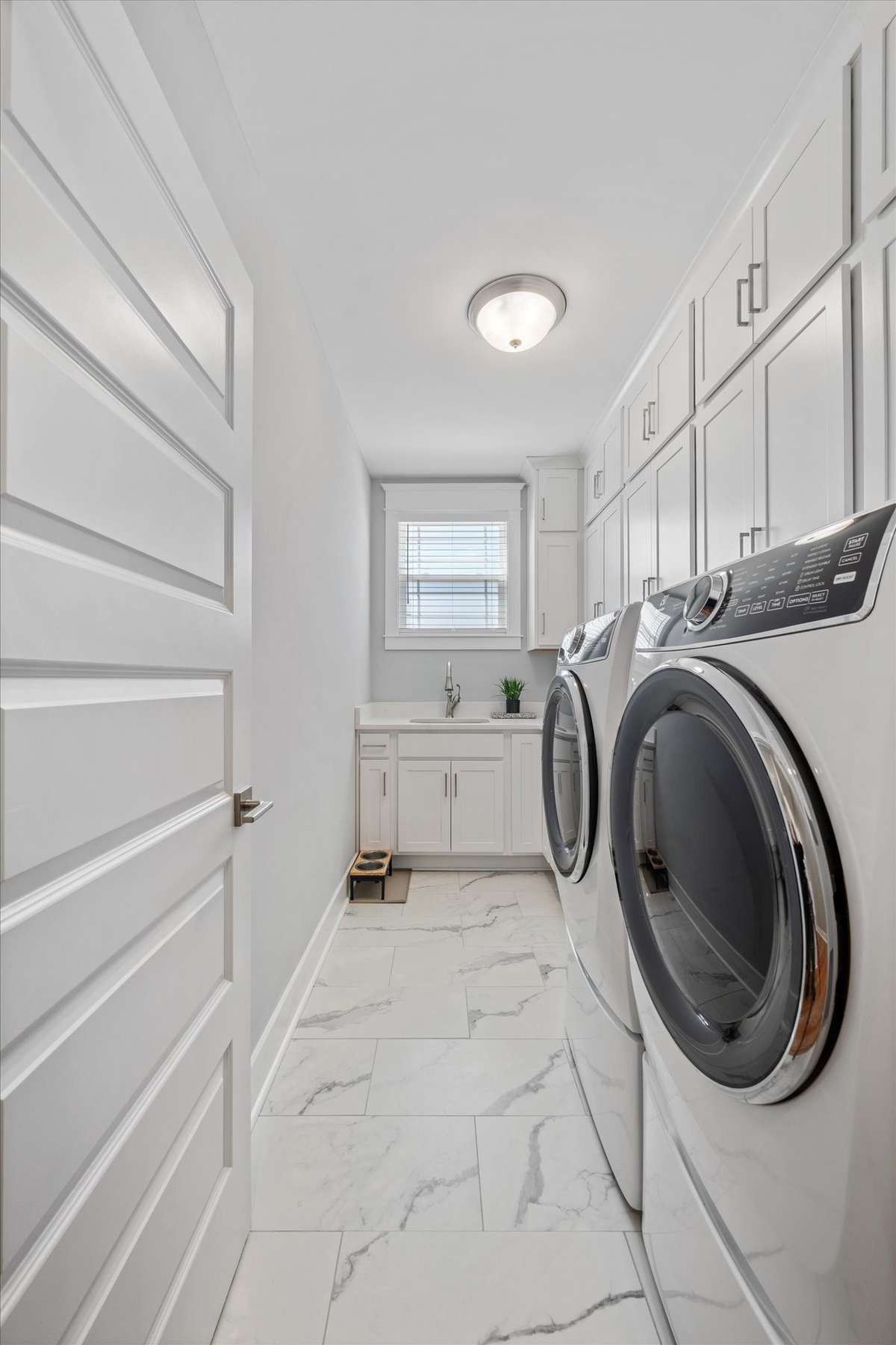 An amazing laundry room with plenty of extra cabinets for storage.