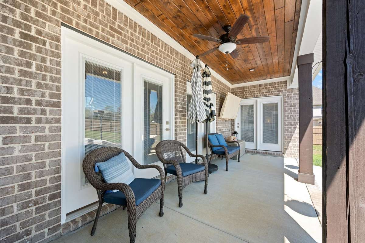 Covered back porch with entrance to primary bedroom, living room, and kitchen.