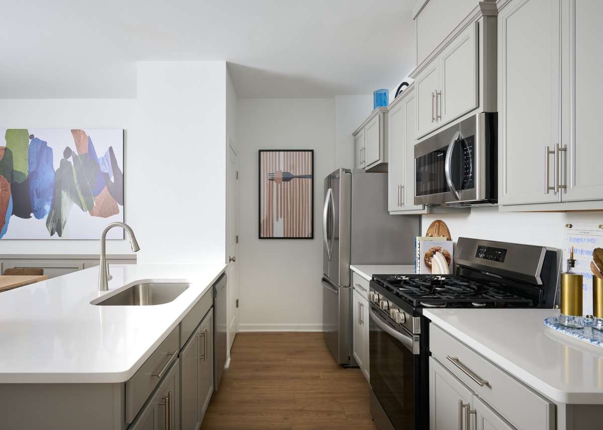 Kitchen has a full pantry, gas appliances, and the microwave vents outside. Photo is of the same floorplan but is the furnished model. Design options may change - See sales for specifics