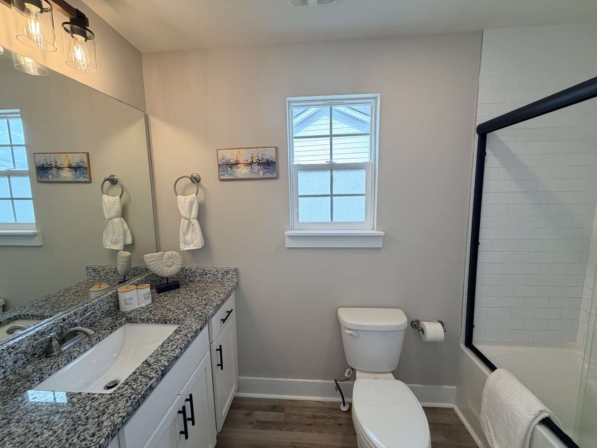 Primary Bath: Beautiful granite counters, large undercount sink, lots of space for toiletries on the counter and in the cabinets below. Combo Tub/Shower features glass shower doors with towel bars. Updated lighting.