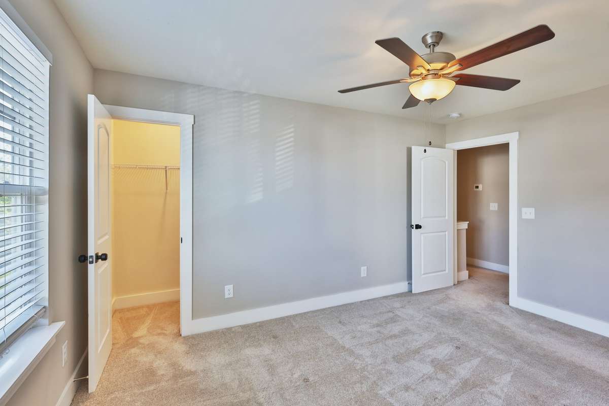 Primary bedroom, second lighted walk-in closet, view of door to hallway.