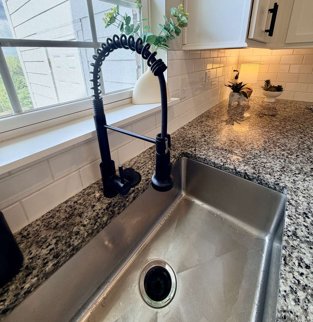 A large under-mount single bowl stainless sink makes larger pots and bowls a breeze. The dishwasher is conveniently to the left of the sink. The pull down faucet has a sprayer mode, and there's a garbage disposal.