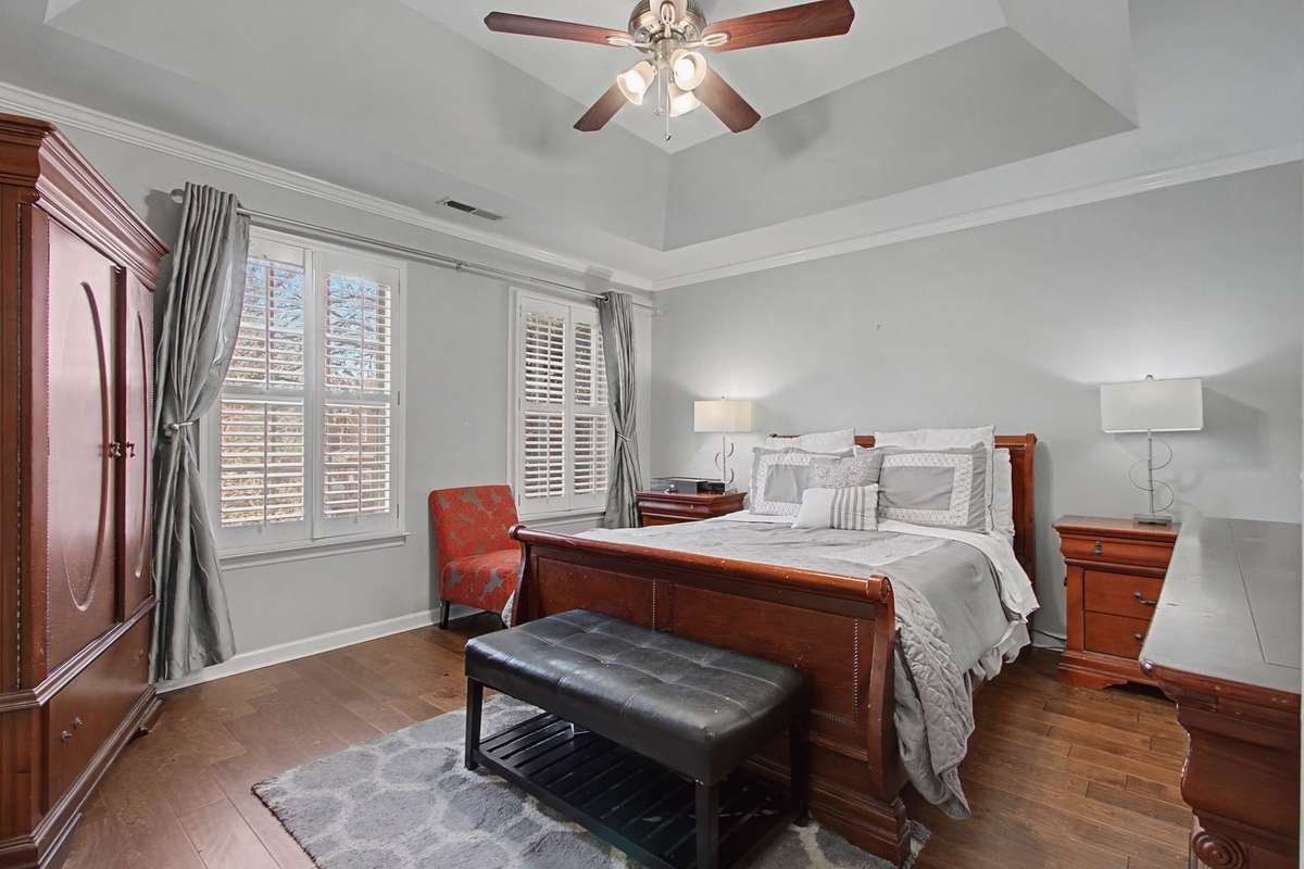 Primary suite has tray ceiling, ceiling fan and 2 large closets.