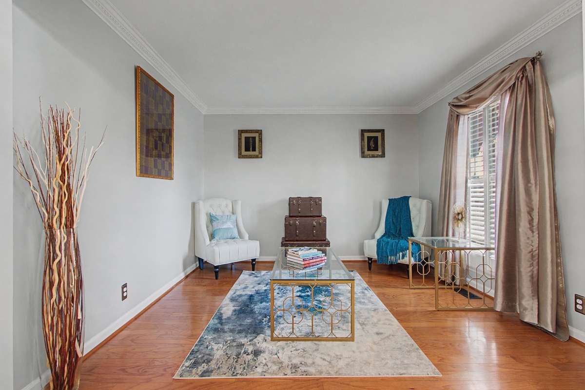 Formal living room with hardwoods & plantation shutters.  Could be nice office space.