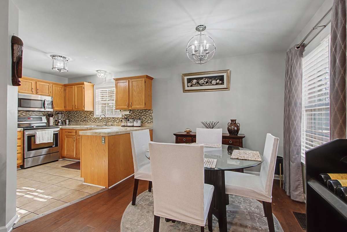 Kitchen has tile floor & backsplash, stainless steel appliances that remain.