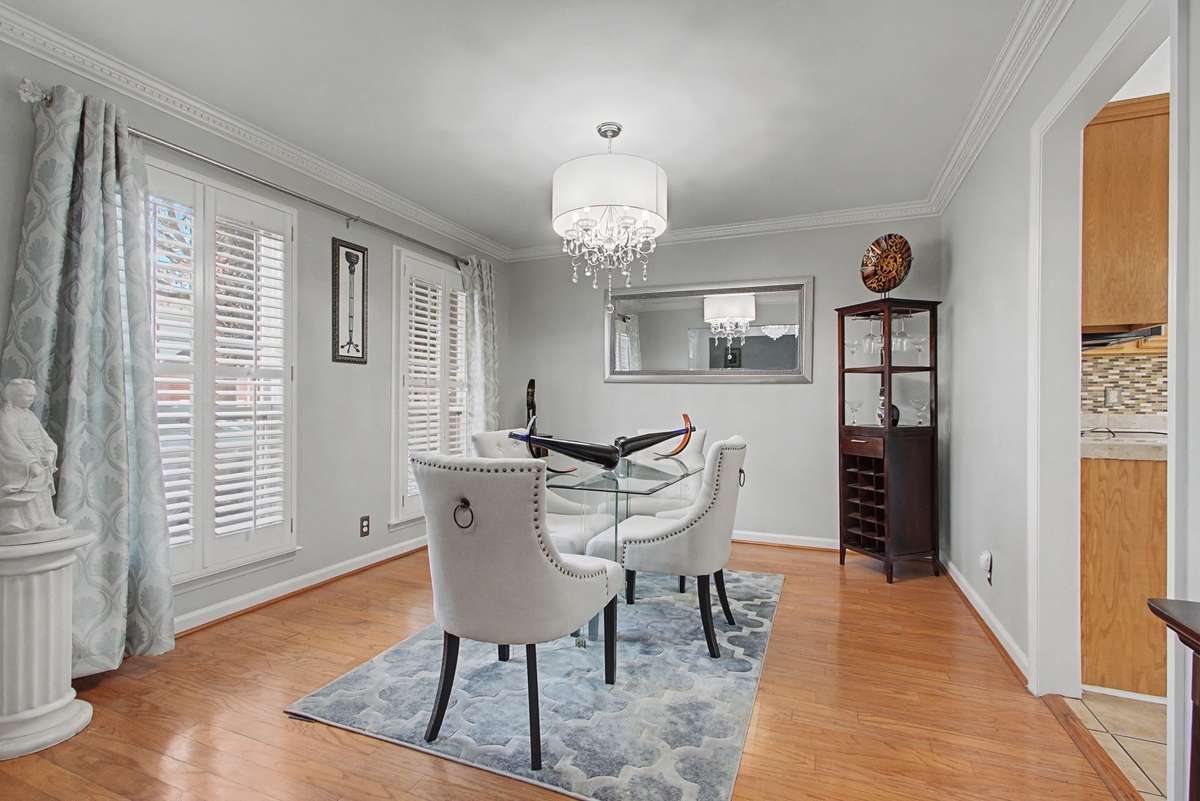 Large light filled dining room has plantation shutters.
