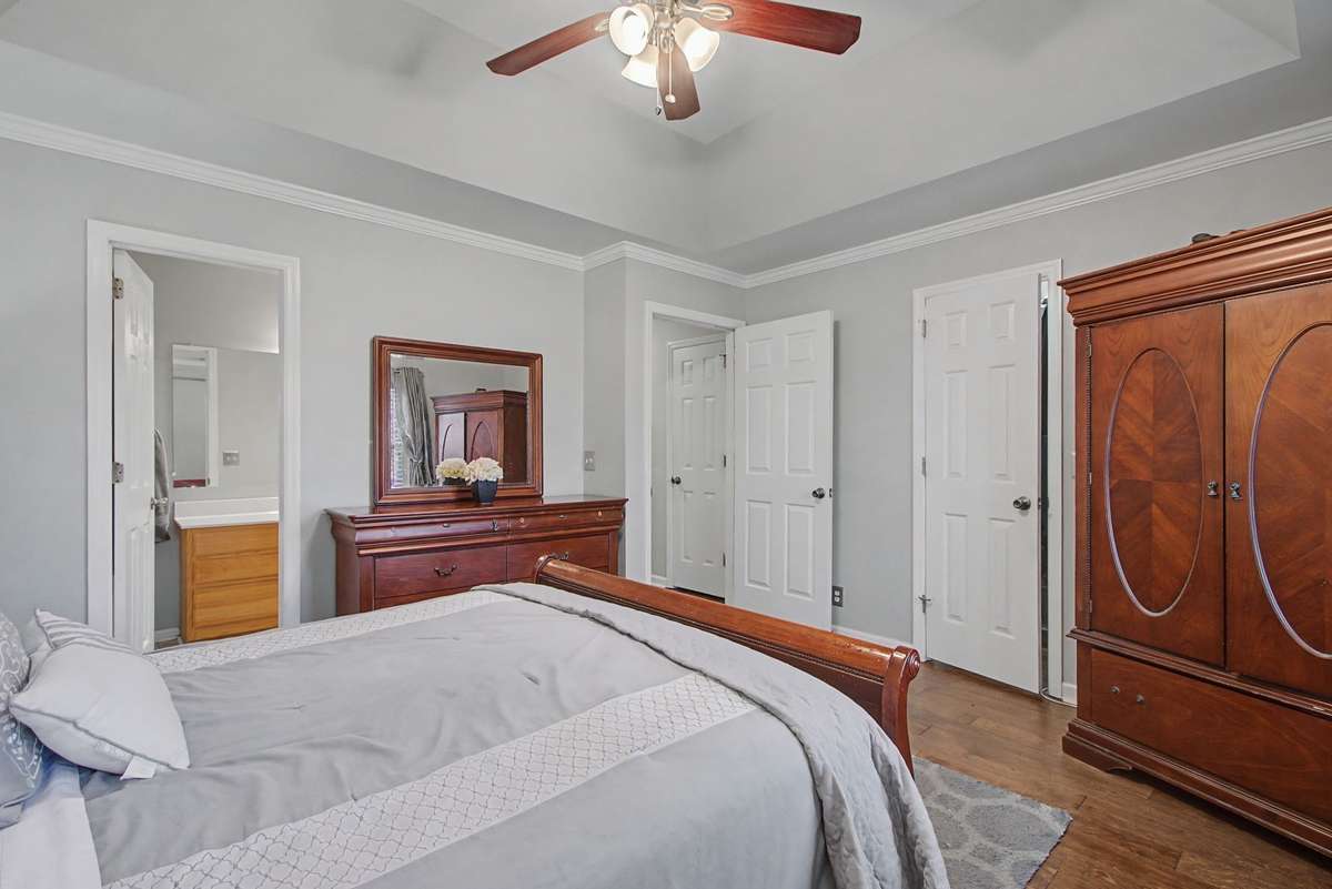 Another view of the primary suite with wood flooring.