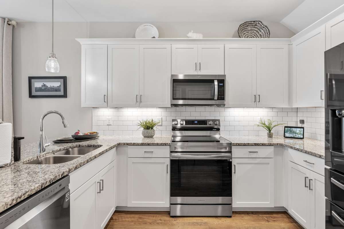 The homeowners added the pendant and under-cabinet lighting to show off the white tiled backsplash and granite countertops.