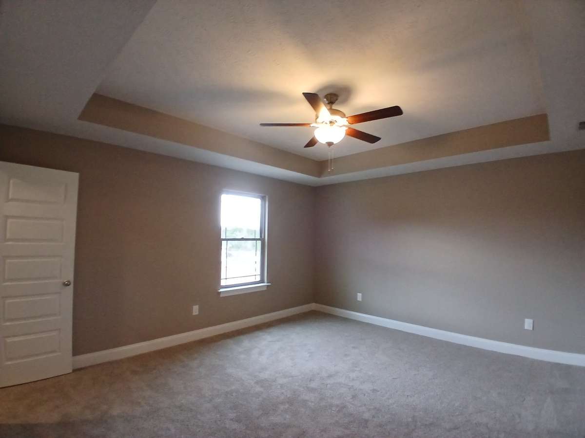 Primary Bedroom with Trey Ceiling and Ceiling Fan.