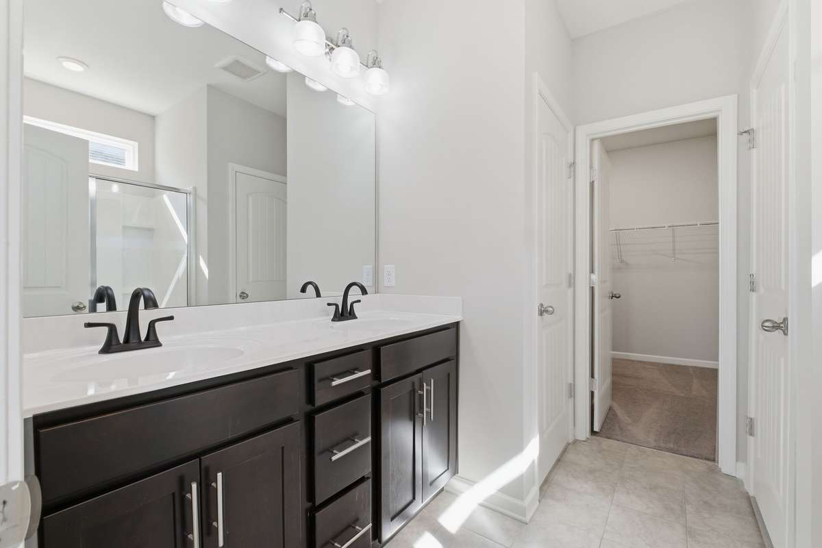 The primary bathroom with double vanities, large closet,  and a water closet.