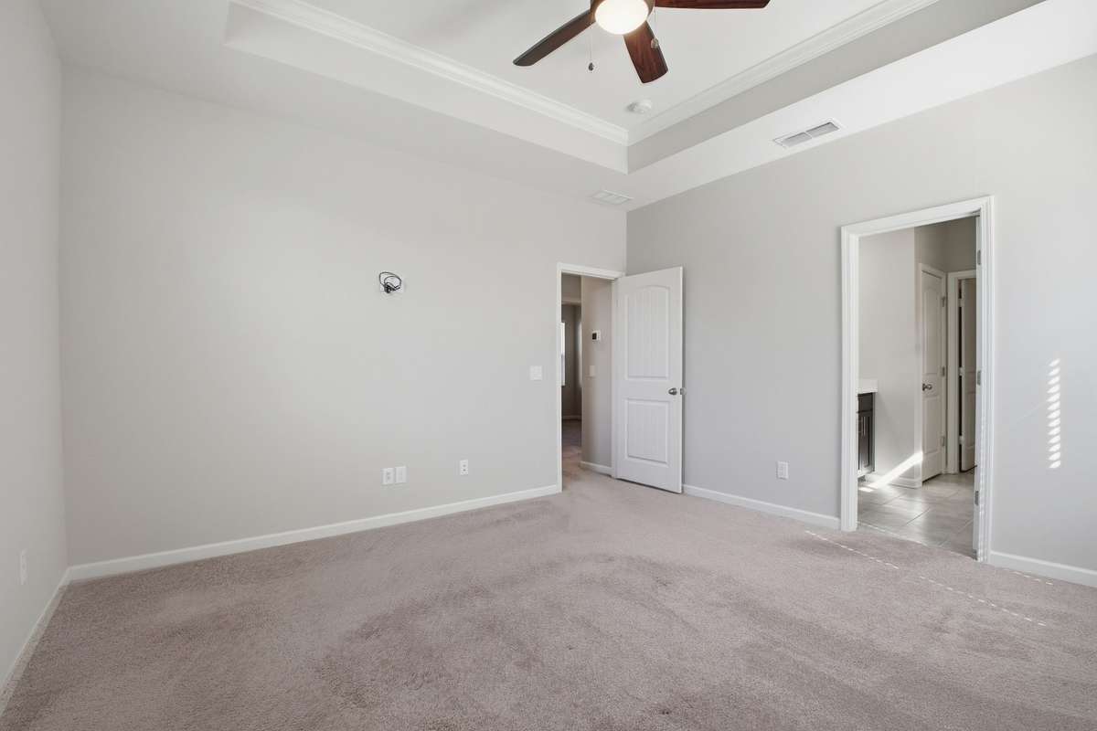 Another view of the primary bedroom with attached primary bathroom.