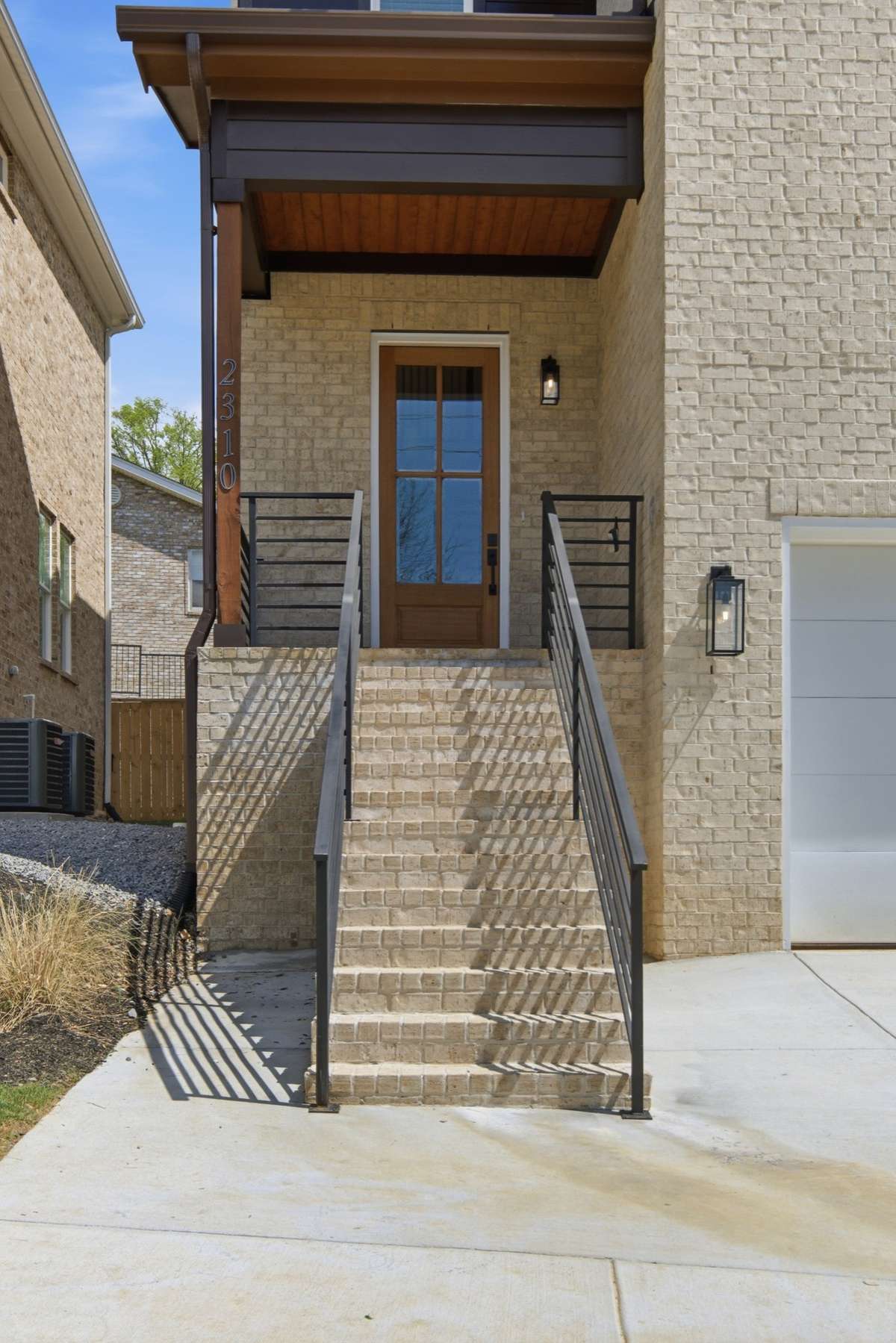 Brick steps, aluminum railing, and beadboard ceiling on the front porch