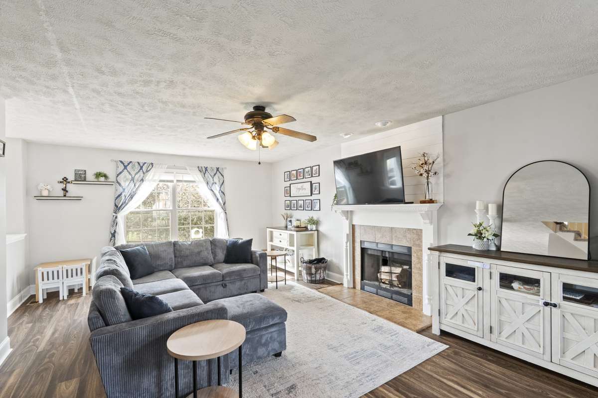 Large open living room off of dining room with views of the kitchen.