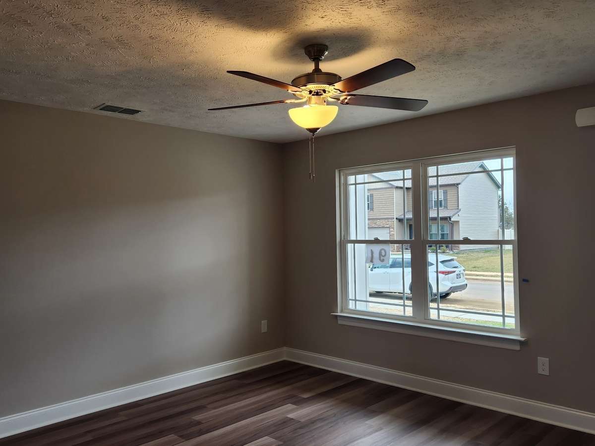 Spacious Living Room with LV Plank Flooring and Ceiling Fan.  
Previous House is in picture.