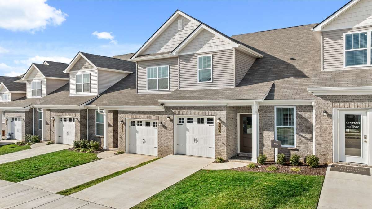 Beautiful brick detail and covered front porch add style to this townhome. Photo of decorated model home of this floorplan, not actual home listed.